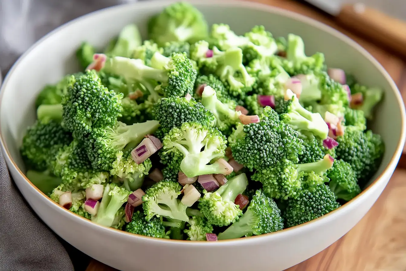 Freshly blanched broccoli in a white bowl on a wooden counter.