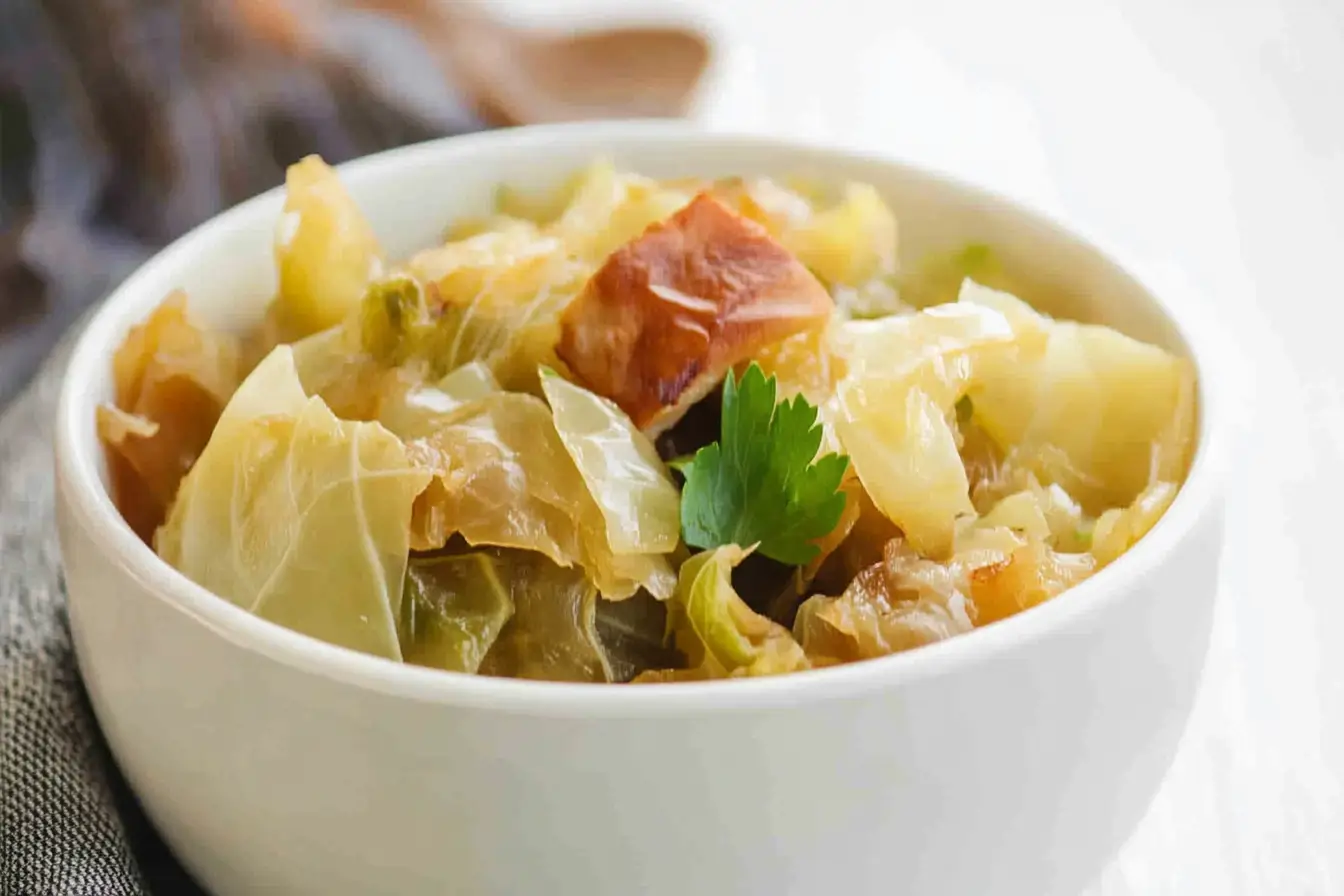 Slow cooker cabbage served in a bowl with fresh parsley